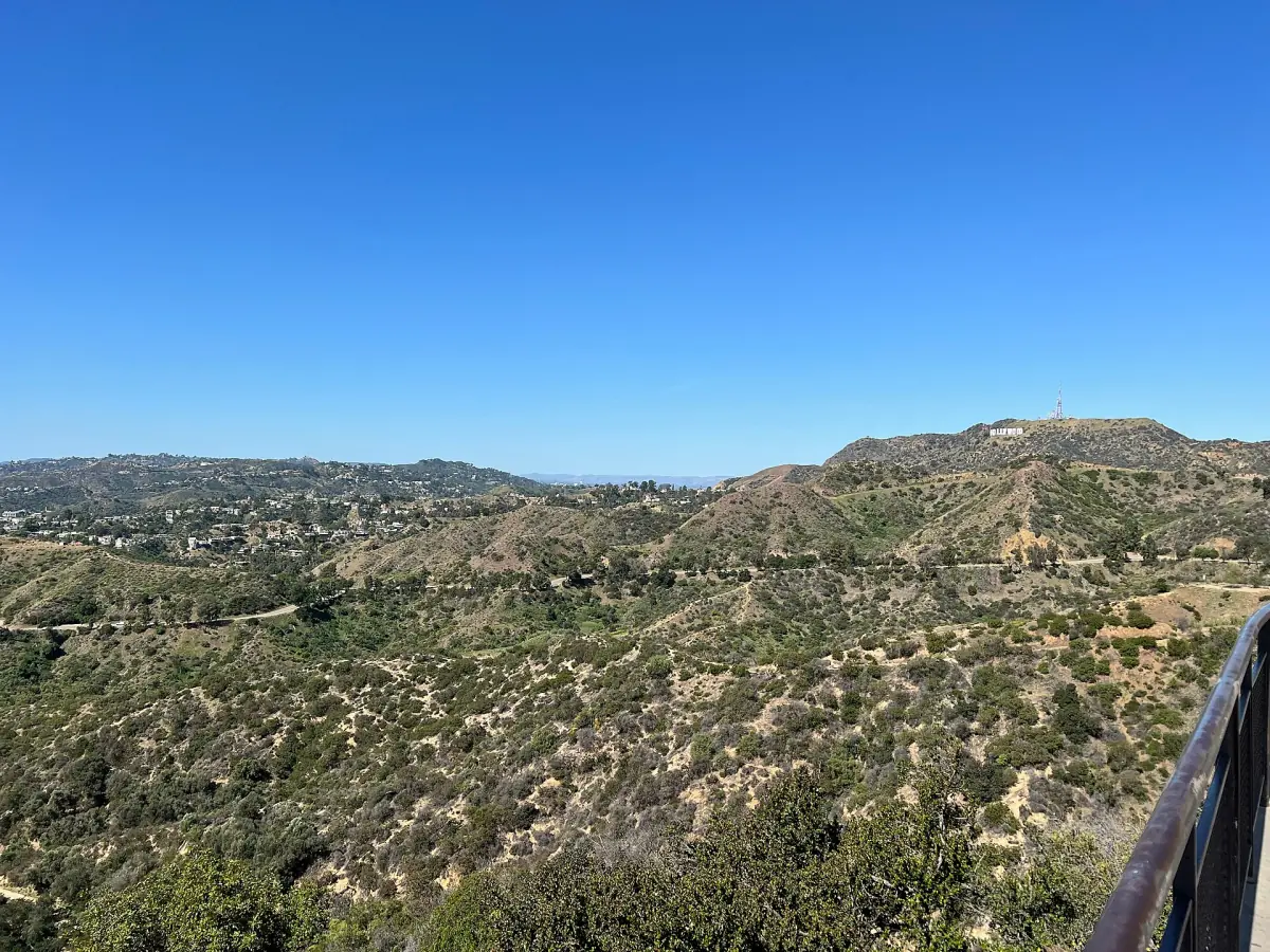 The sign above chaparral-covered hills